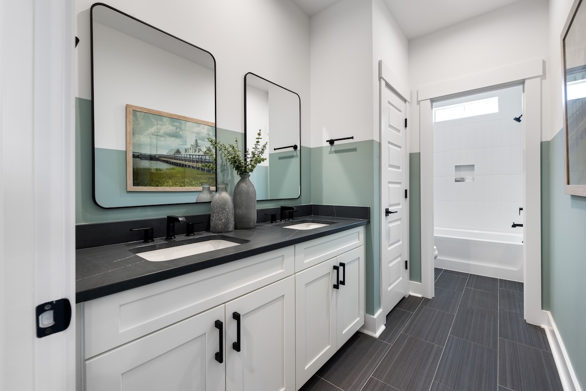 Modern secondary bathroom with closet space and dual sink vanities.