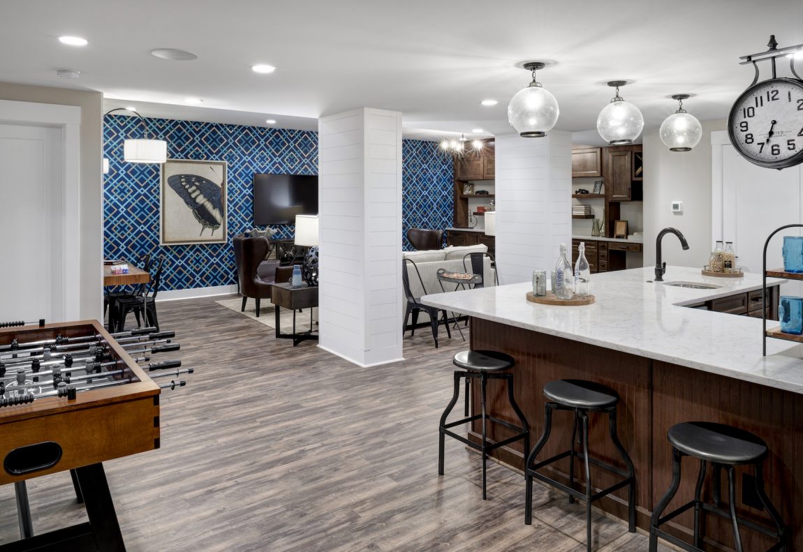 Luxury finished basement with wallpapered accent wall