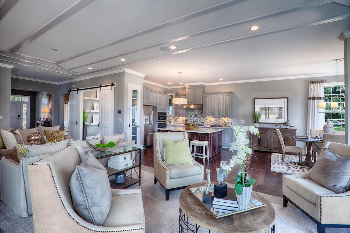 A charming great room and kitchen that have similar interior design styles.