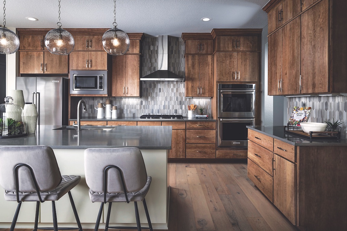 Kitchen with dark wood cabinets, quartz countertops and stainless steel appliances