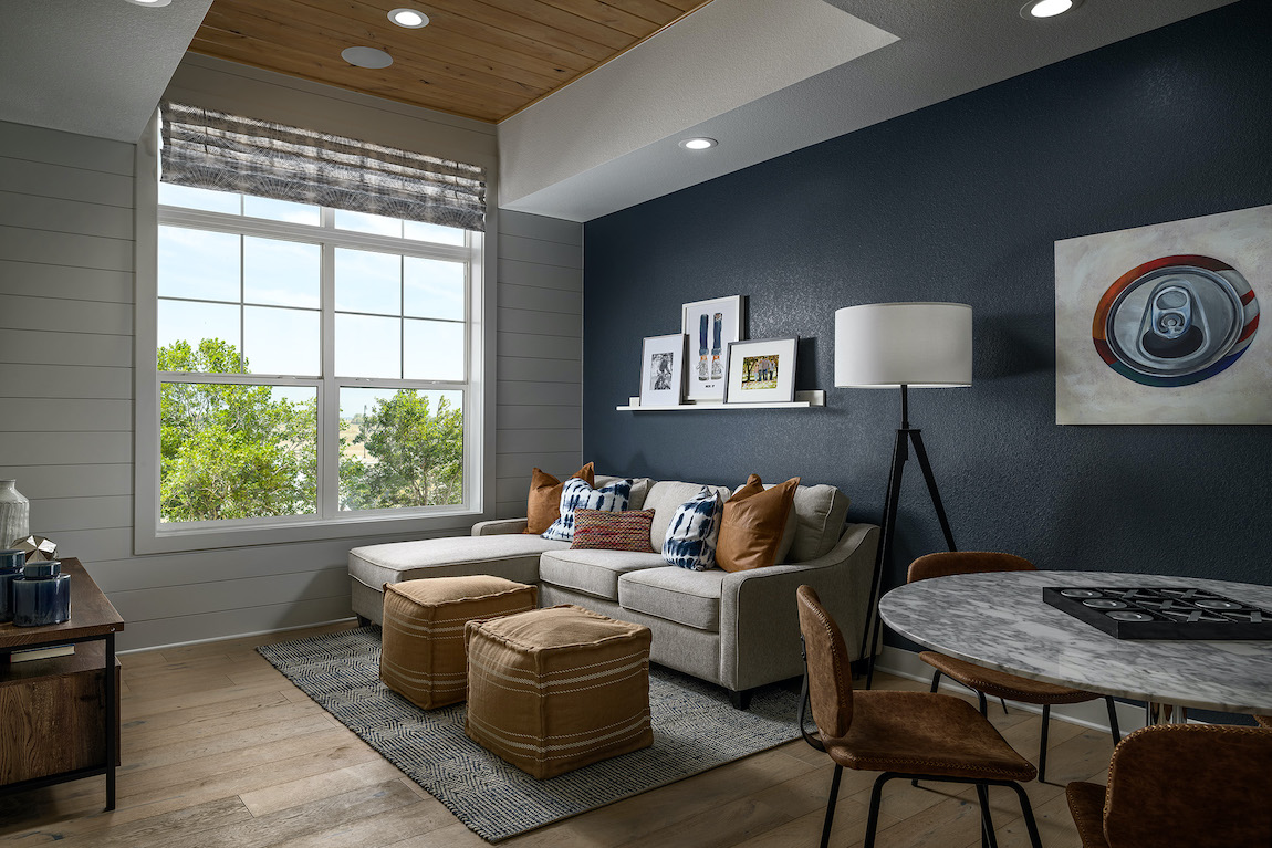Loft with blue accent wall, game table and wall art