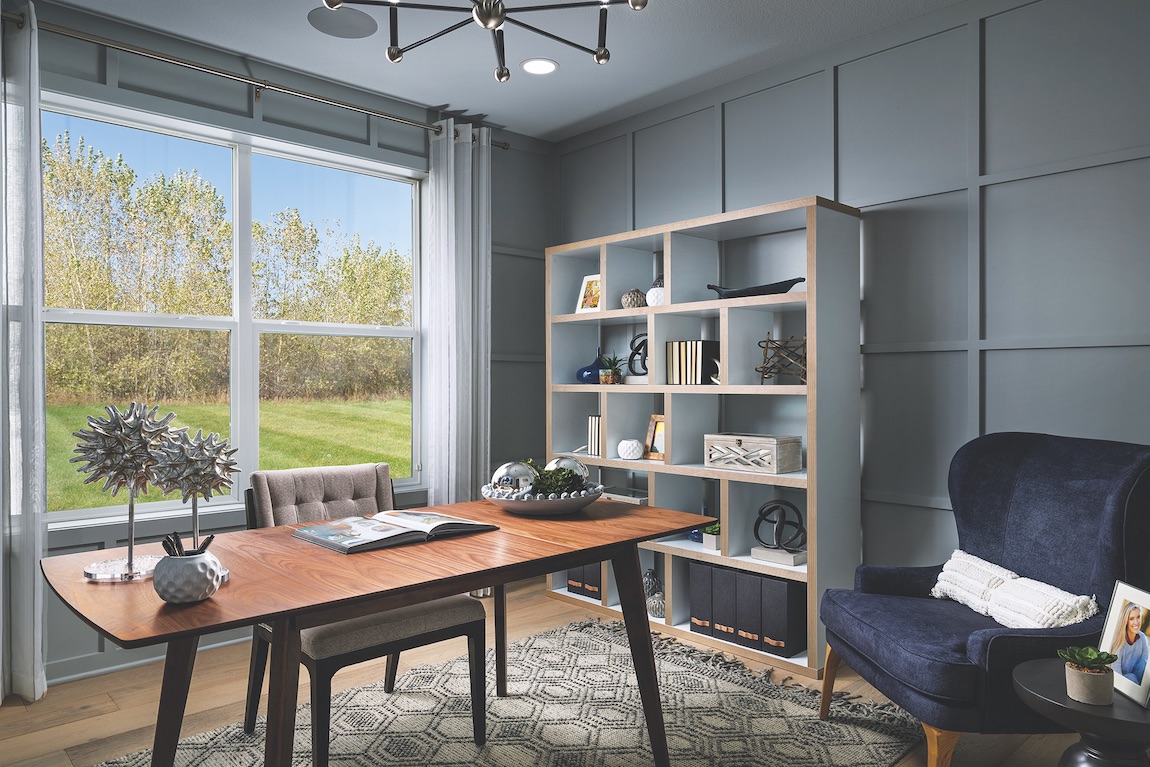 Office with bookshelf, wooden modern desk and blue armchair