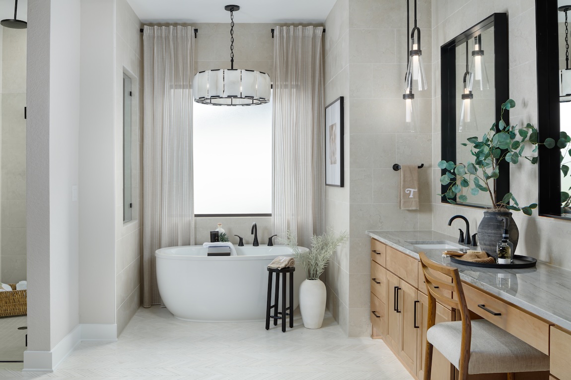 luxury bathroom with vanity and tub centered under a window
