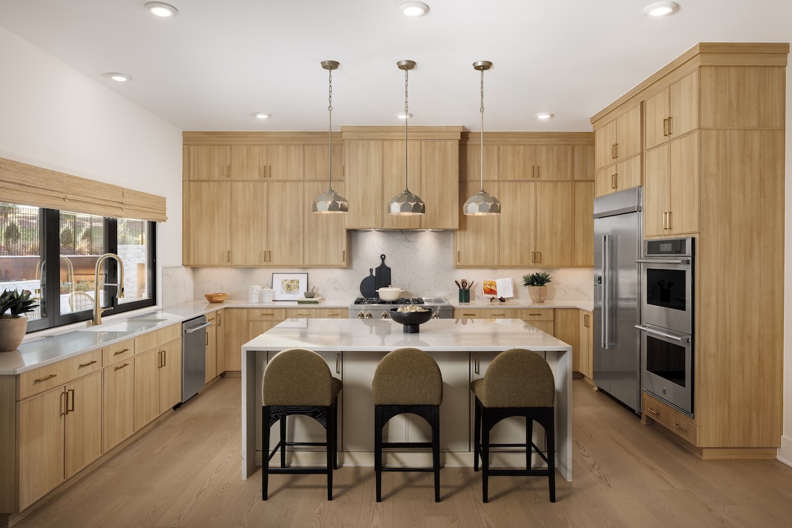 Modern kitchen with waterfall island and wooden cabinetry.