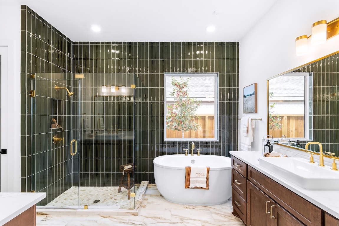 primary bathroom with freestanding tub and green tile.
