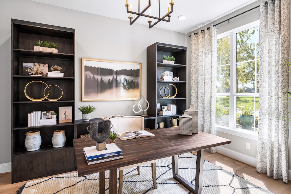 Modern home office with large wooden desk and shelves for storage.