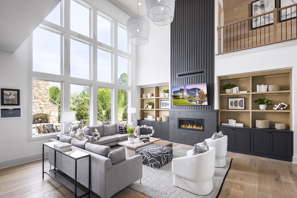 Two-story great room with black accents and large windows to the outdoor living space.