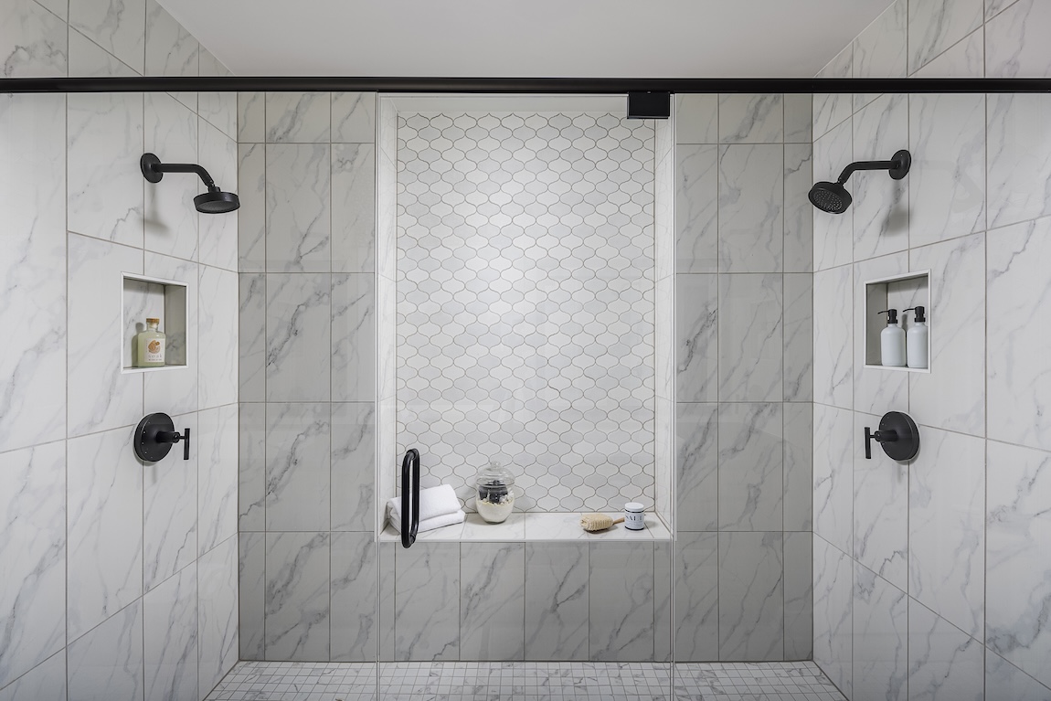 White marble tile shower, double shower head, matte black accents