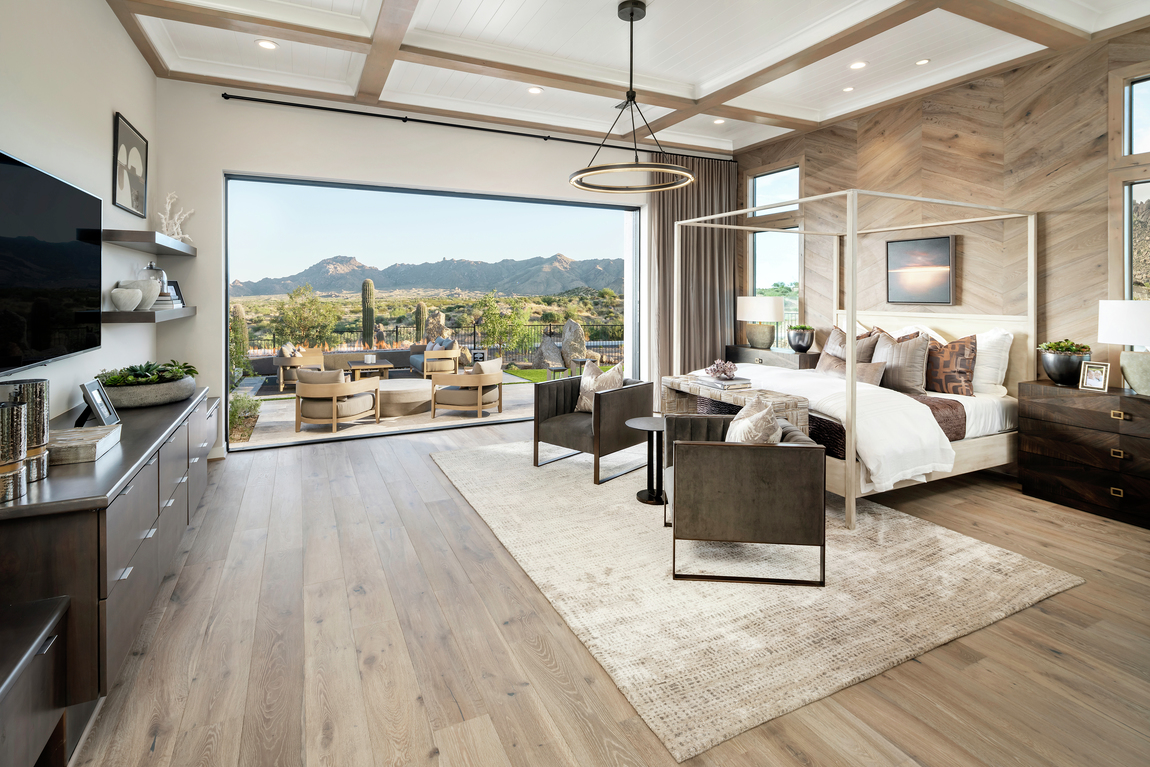 A rustic bedroom in a luxury home with sliding doors that open to a patio.
