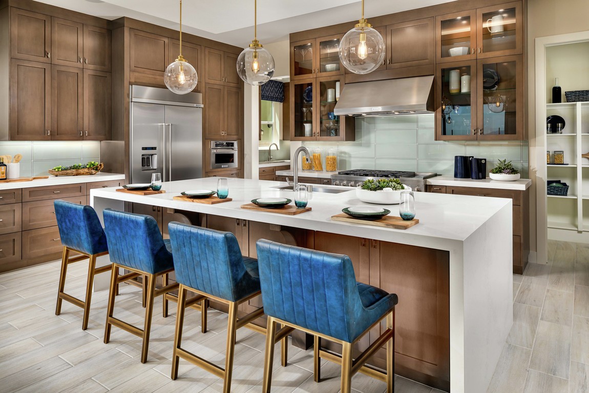 A luxurious kitchen with vibrant blue barstools along the wooden kitchen island.