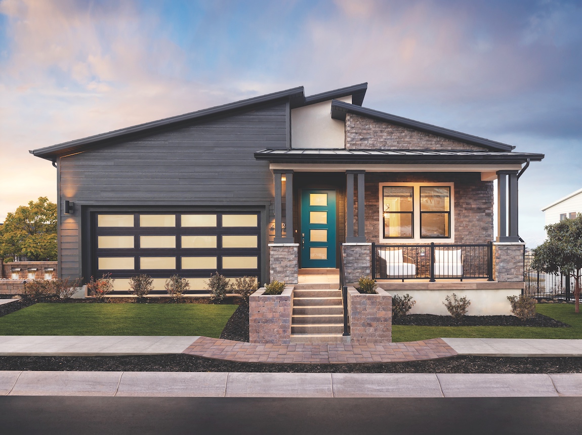 A contemporary Toll Brothers home with a bright turquoise exterior door. 
