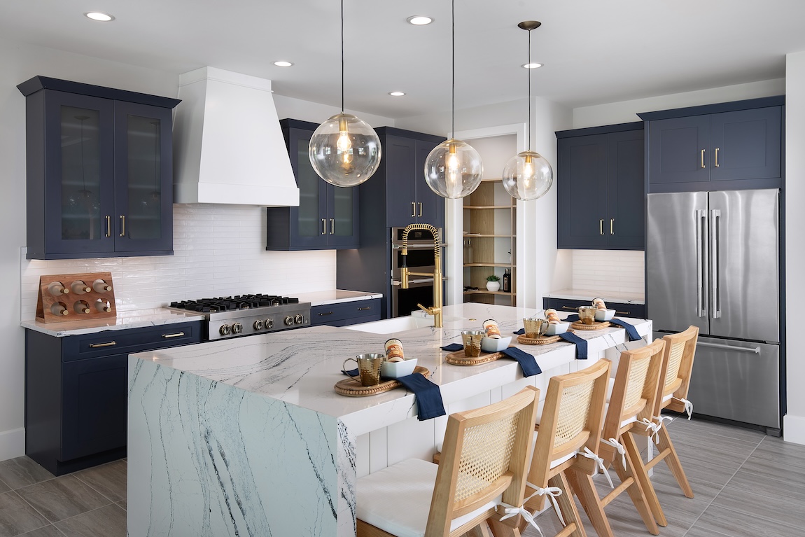 Luxury kitchen design featuring two-toned blue and white kitchen with waterfall island. 