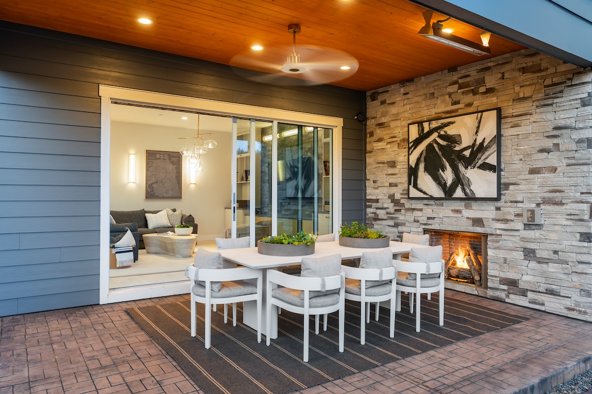 Outdoor dining space with seating for 8, featuring tabletop greenery