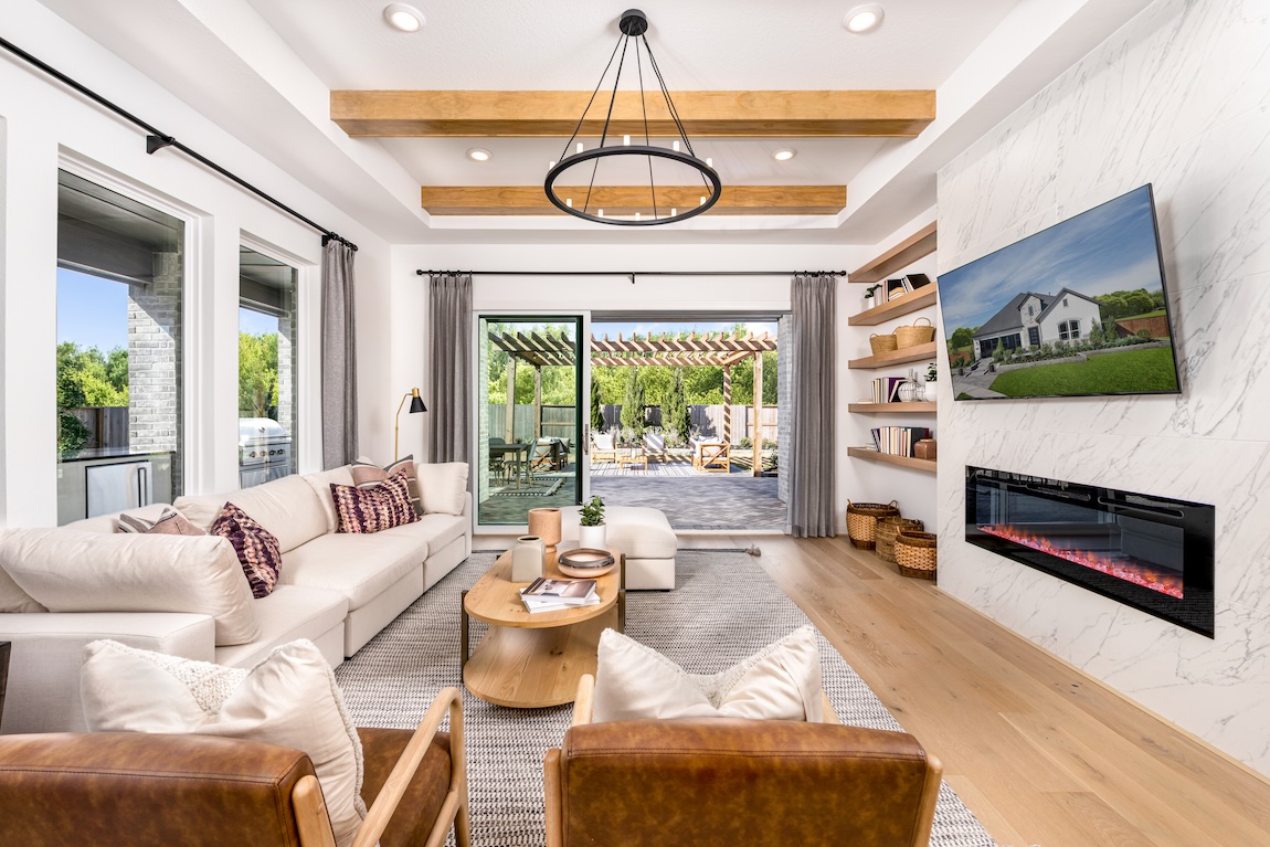 luxe interior design featuring indoor-outdoor transition, wood ceiling accents, and modern fireplace