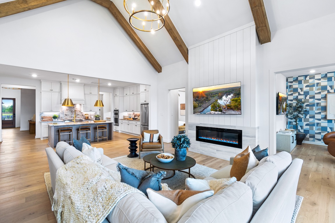 luxe modern farmhouse interior design highlighted by open-concept layout, modern fireplace, and wood ceiling accents