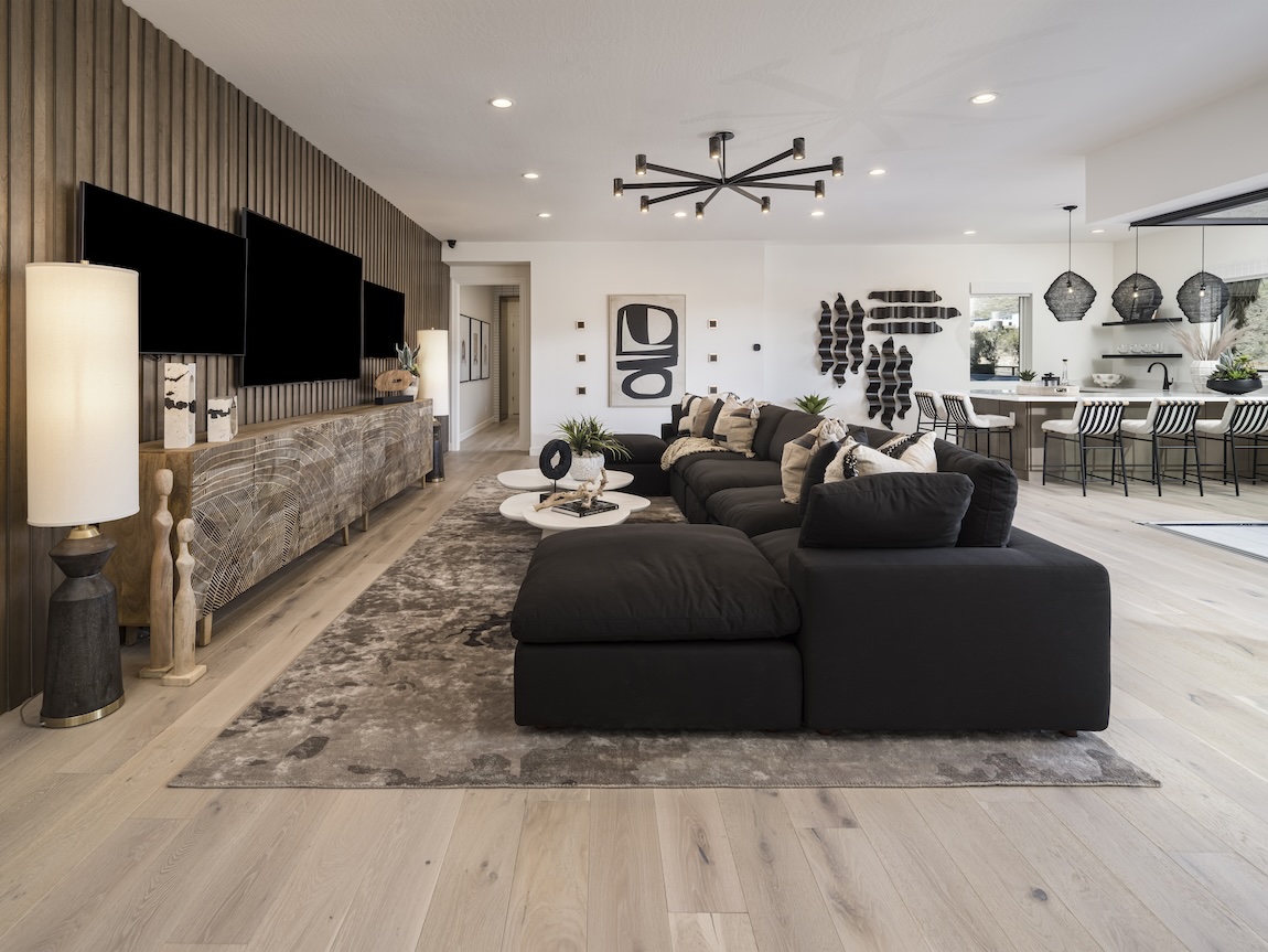 spacious living room with expansive couch and multi-tv setup