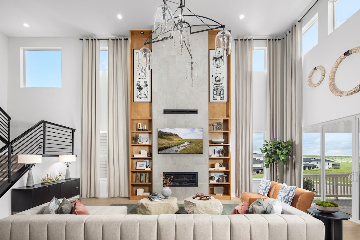 gorgeous new industrial great room highlighted by chandelier and muted fireplace accent wall