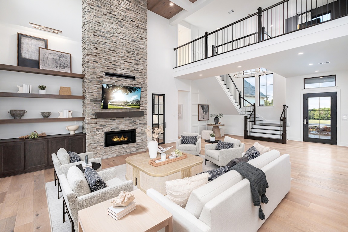 two-story great room featuring stone fireplace design