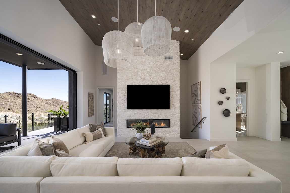 light, airy great room highlighted by eye-catching lighting fixtures and stone fireplace design