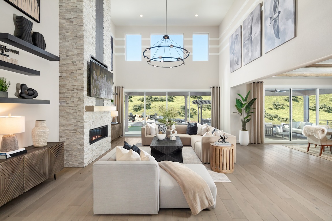 two-story great room with accent fireplace wall and ample natural lighting