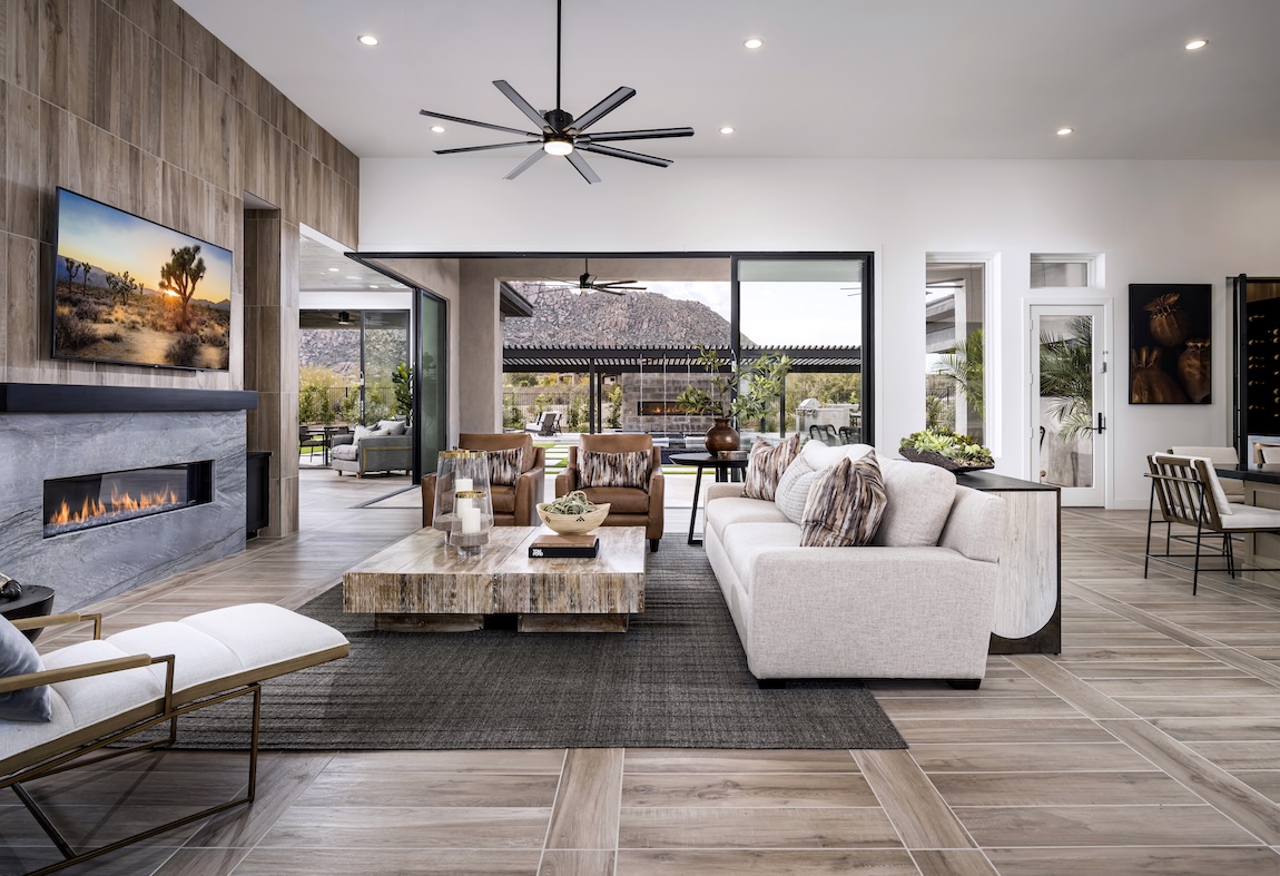 Interior image of living room with view to backyard with stone and wood elements by Toll Brothers. 