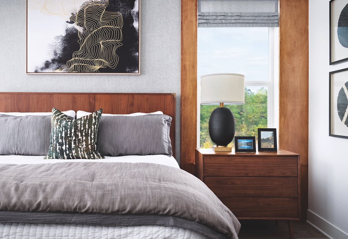 Luxury bedroom by Toll Brothers featuring wooden bed and matching nightstand in Parker, Colorado. 