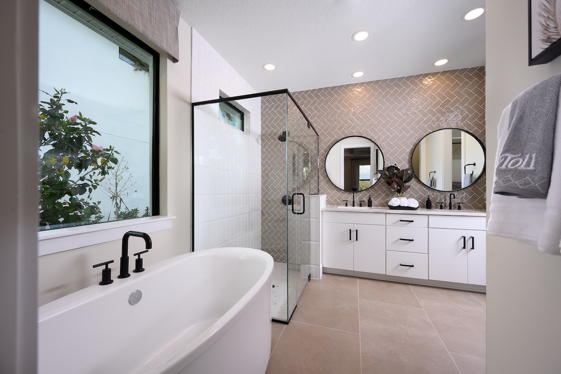 Luxury kitchen design with tile accent wall, circular mirrors, and matte black finishes in Vero Beach, Florida. 