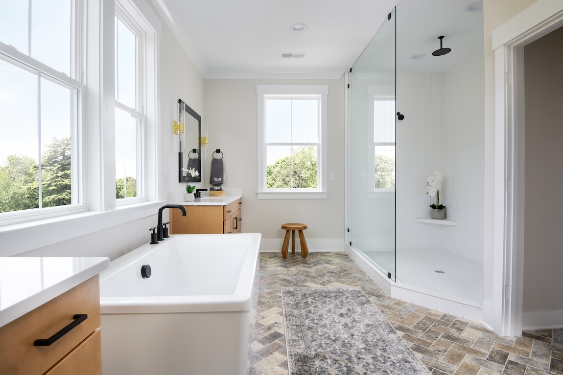 spacious bathroom highlighted by herringbone floor tile design