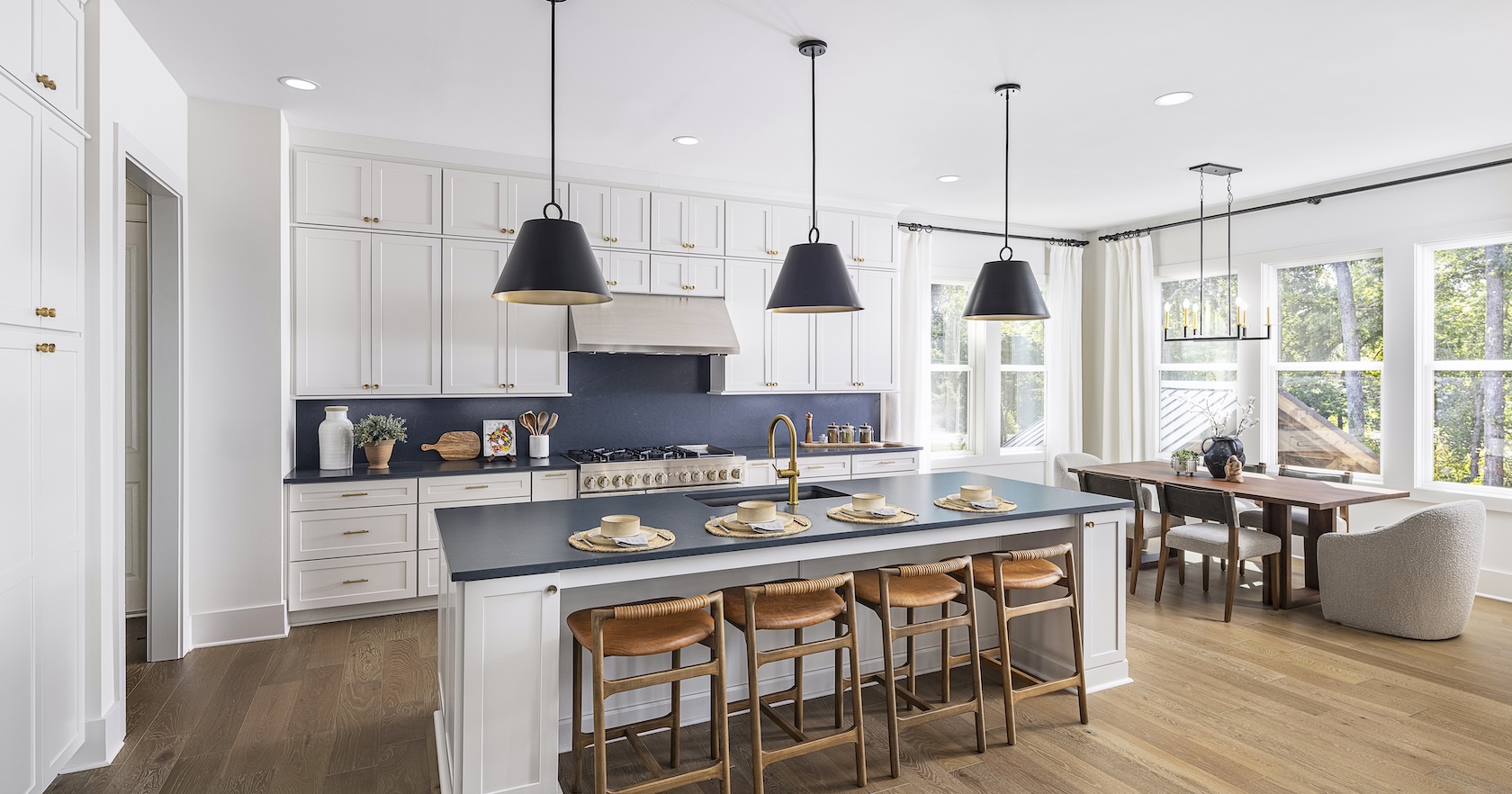 Luxury kitchen with matte black light fixtures, blue backsplash and wood accents and flooring