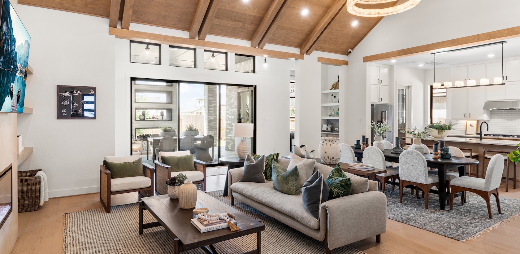 Luxury living room with matte black and wood accents with pitched ceiling and beam accents