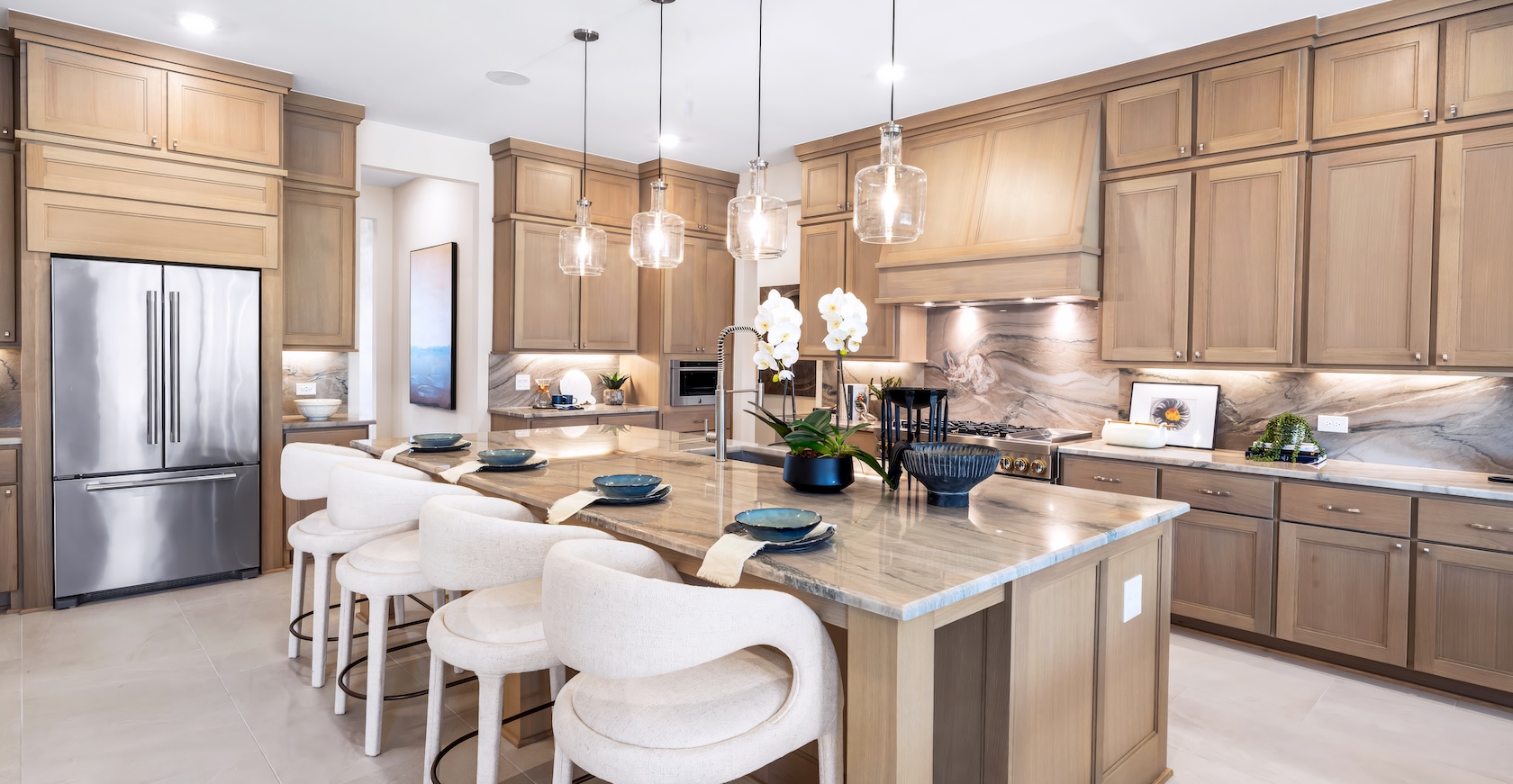 Luxury kitchen design with island featuring white barstools and white quartz countertop.